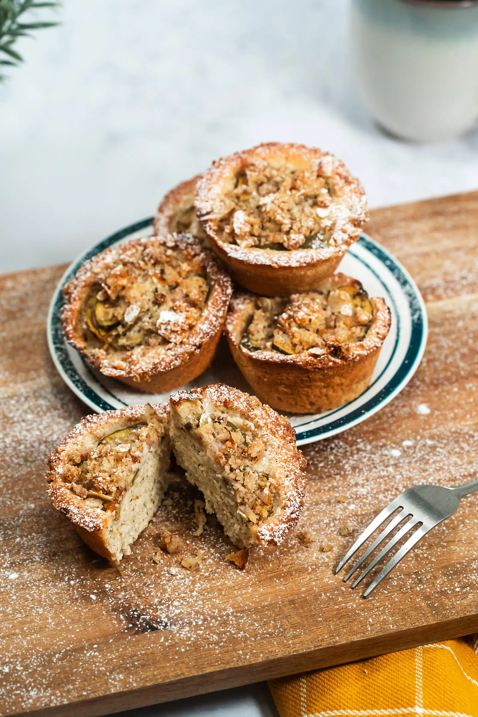 Feijoa Friand stacked on plate one cut open on wood board