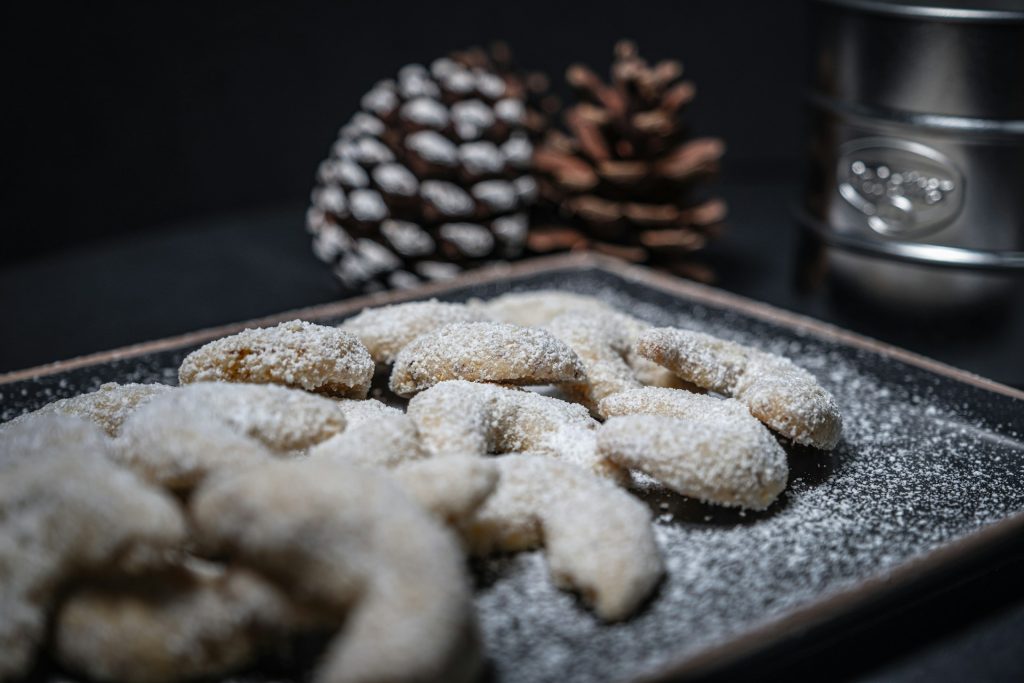 Vanillekipferl on a tray with pine cones in the background