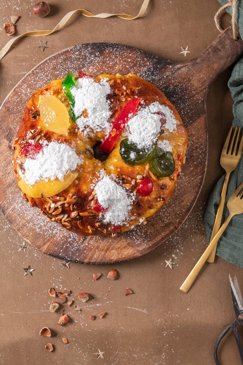 Bolo Rei with candied fruit and icing sugar on kitchen countertop