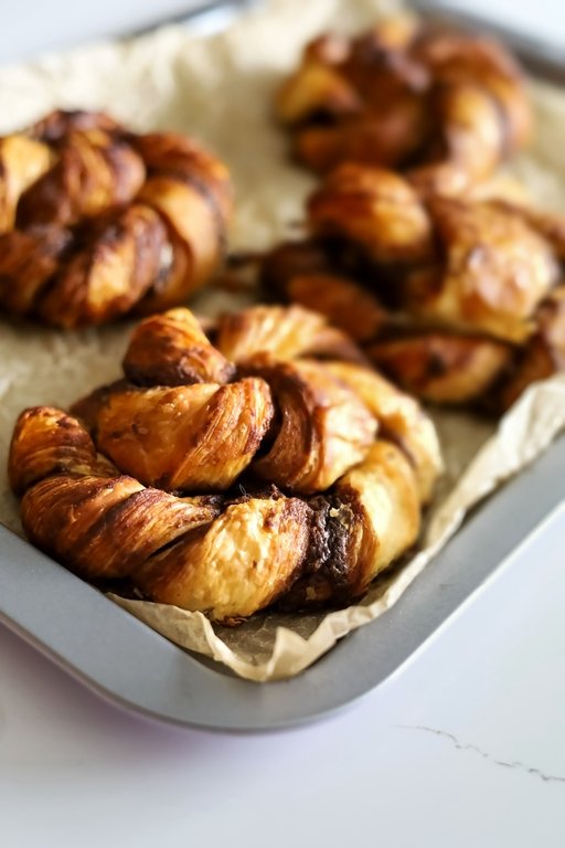 Vegan cinnamon knots on a tray with baking paper