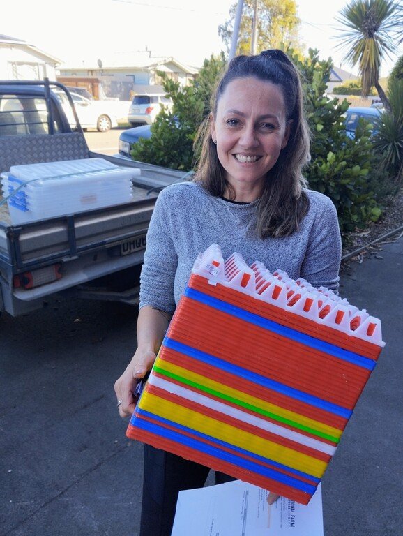 Gretha from Nutritional Farm collecting a stack of empty reusable plastic egg trays from Bellbird Bakery in Woolson, Christchurch