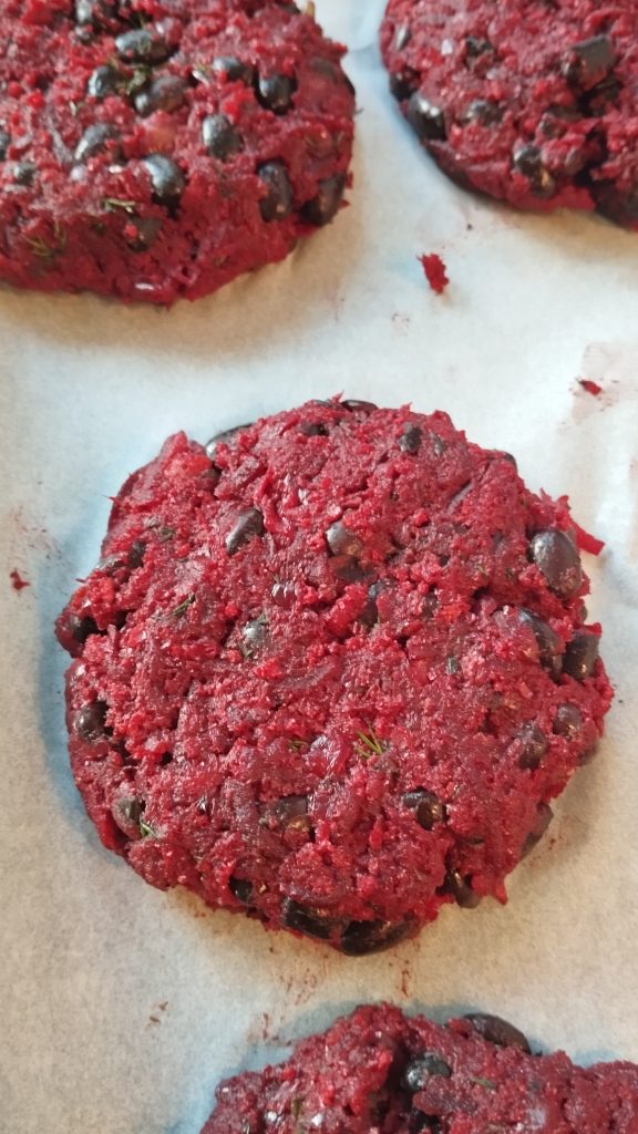 Untamed Earth Beetroot Black Bean burger patties resting on baking paper before cooking