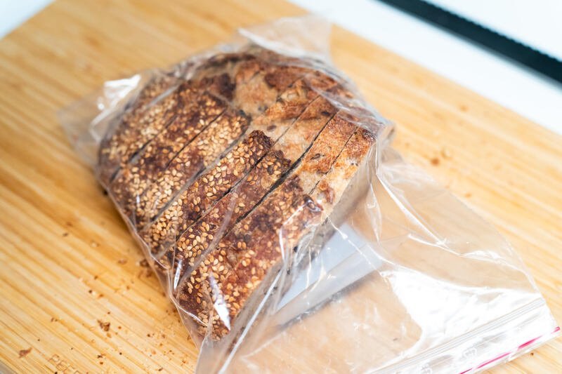 Half a sliced Seeded sourdough loaf in a plastic bag, ready to freeze
