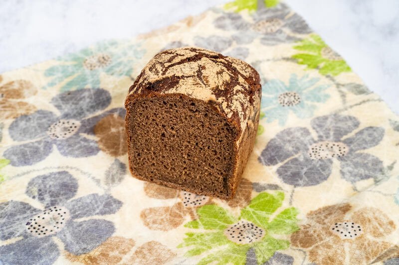 Half a Bellbird rye sourdough loaf on top of a beeswax wrap