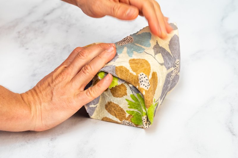 Alice wrapping a half rye sourdough loaf in a beeswax wrap