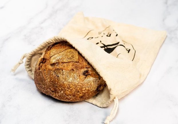 Walnut sourdough in Bellbird cotton bread bag on white bench
