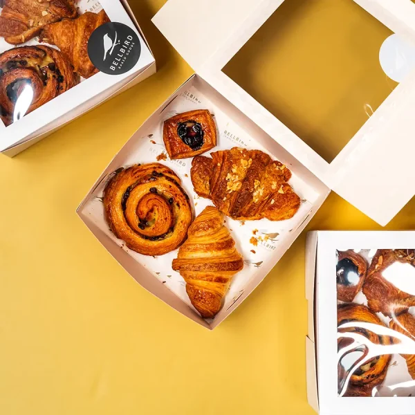 The Classic Box on yellow Background with Croissant, Pain Aux Raisins, Almond Croissiant and Mini Fruit Danish