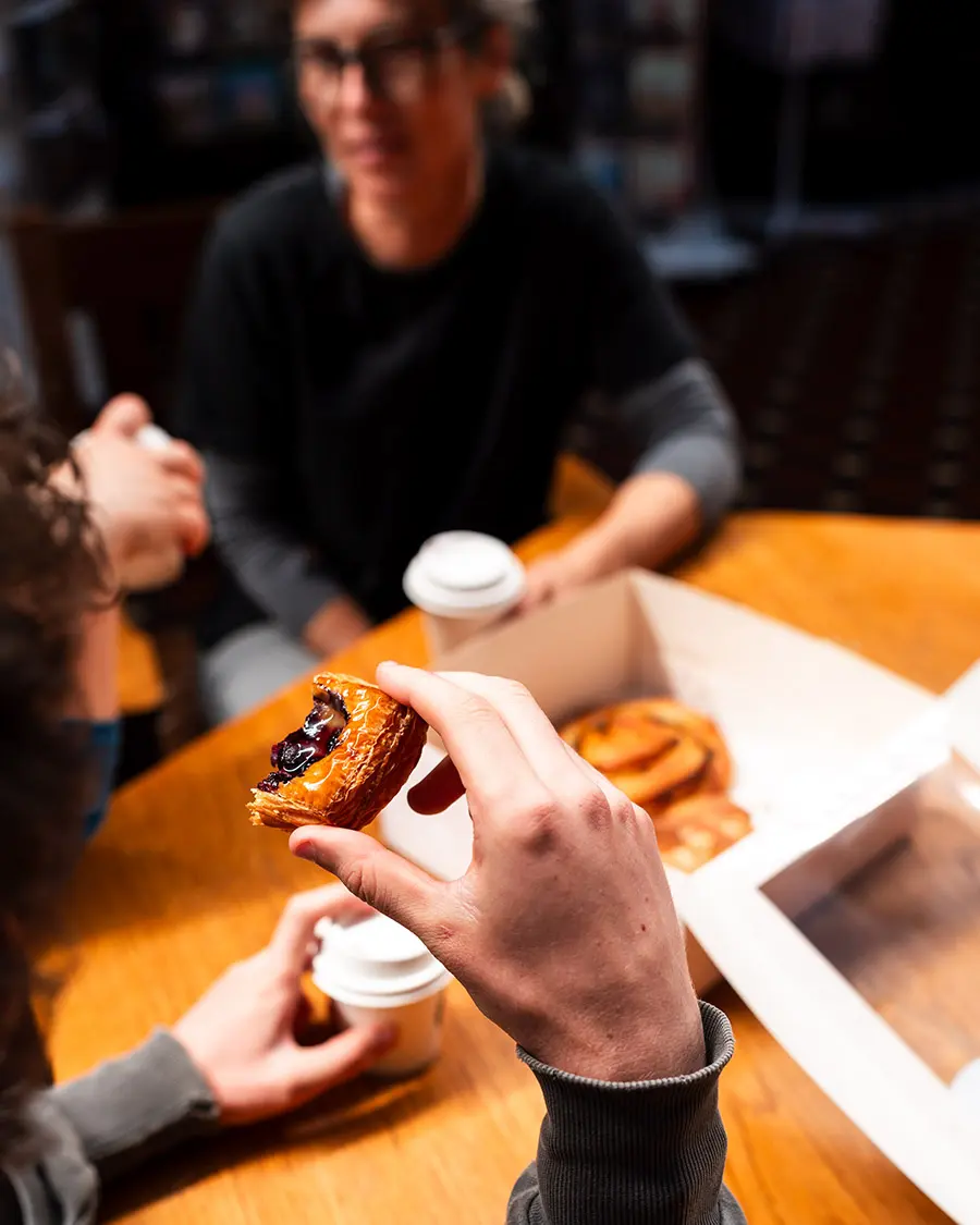 The Classic Box with hands grabbing pastries with Croissant, Pain Aux Raisins, Almond Croissiant and Mini Fruit Danish