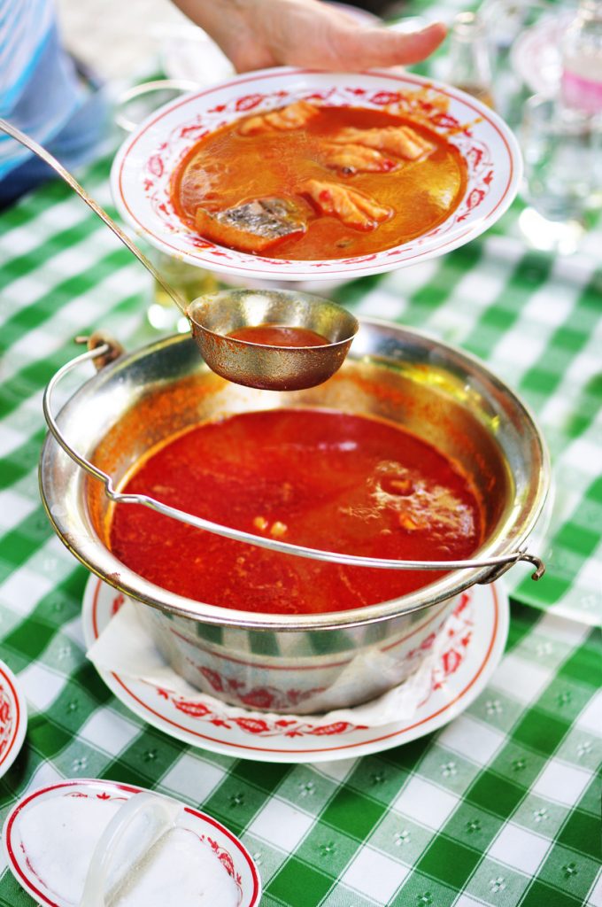 Pouring traditional Hungarian fish soup - Halászlé