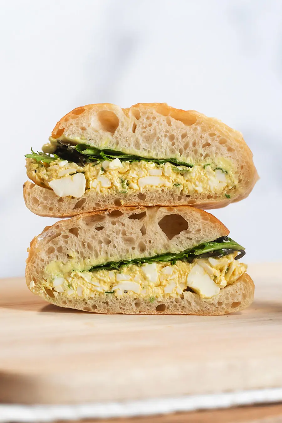 Egg Sandwich Cut in Half on wood board