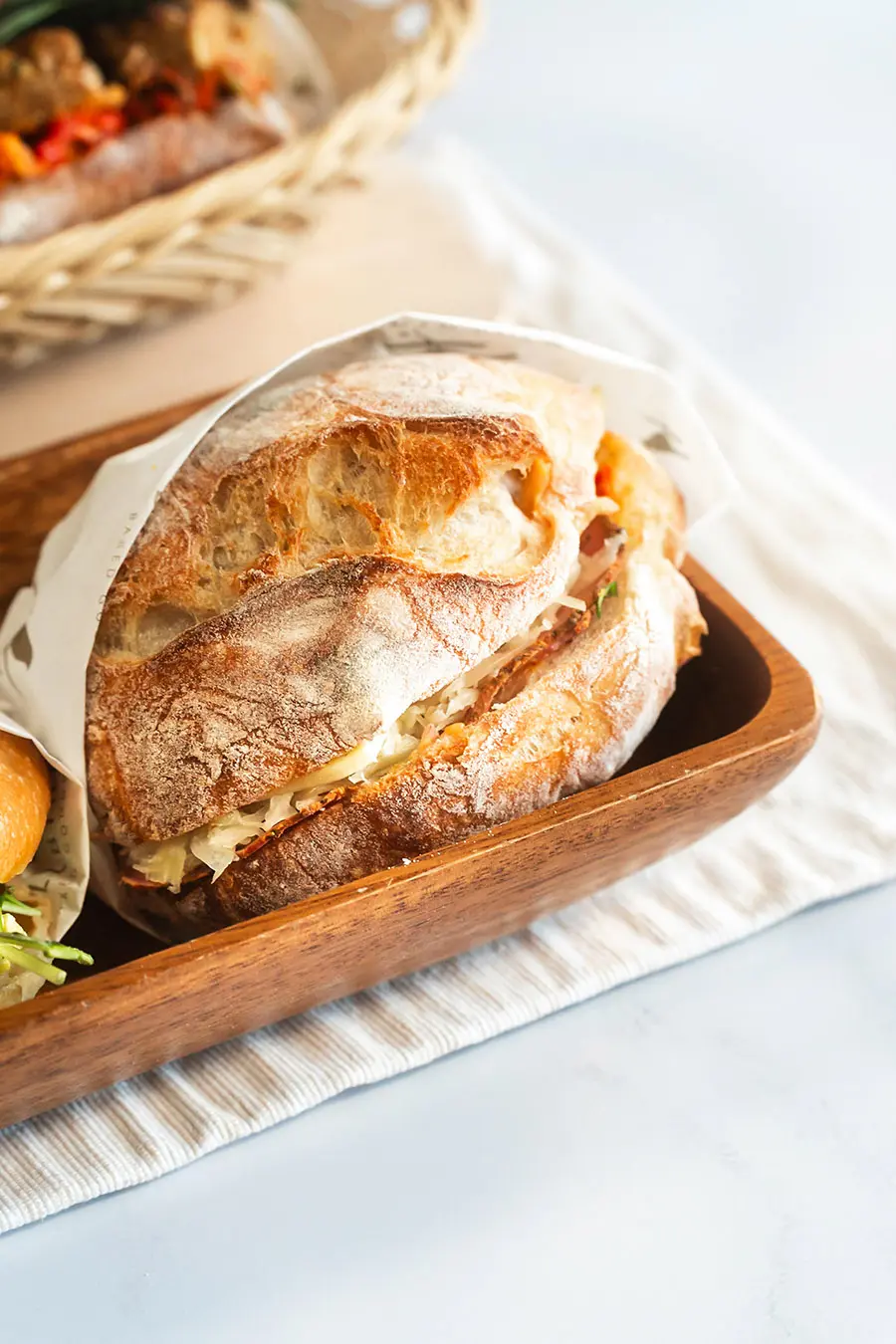 The Reuben Sandwich in wood basket on Wood Board on white background