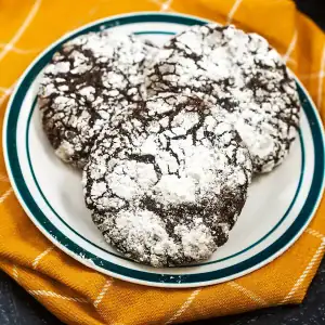 Chocolate Crinkle Cookie on plate and yellow kitchen towel