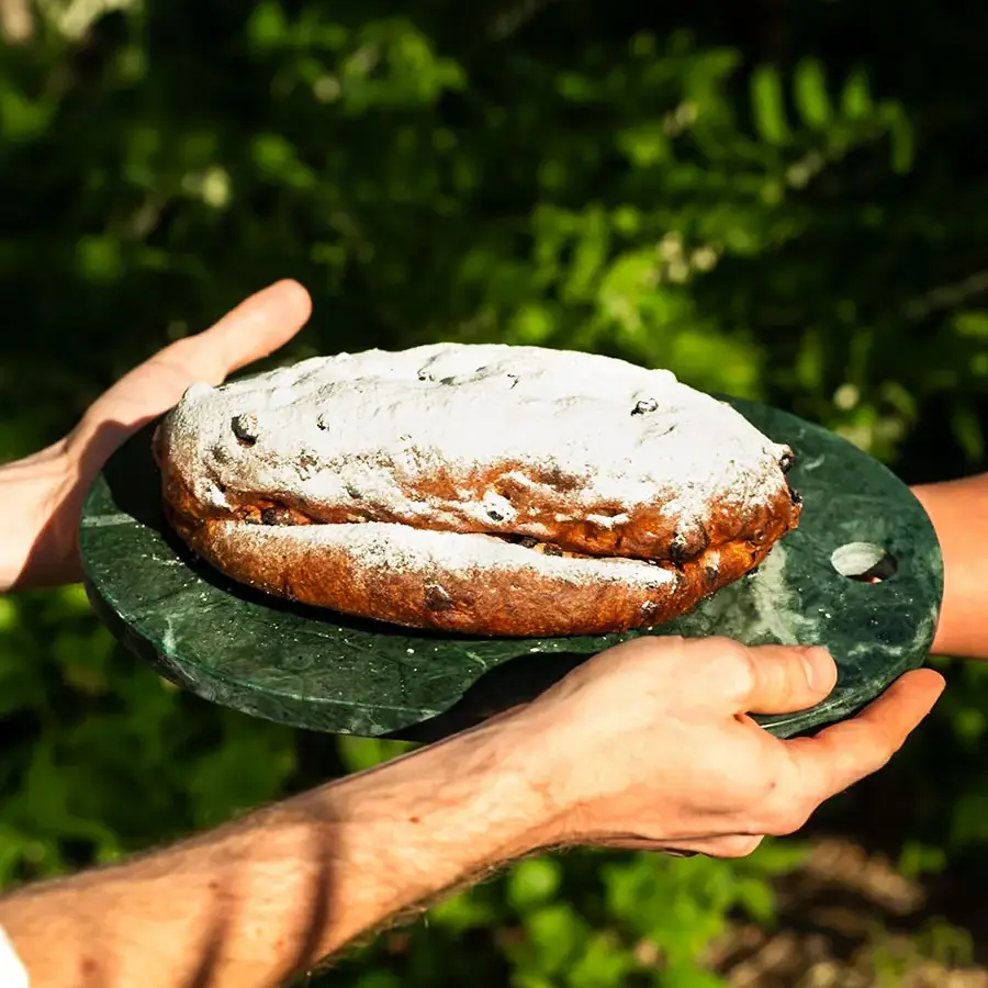 Fruit Stollen held in hands being passed over