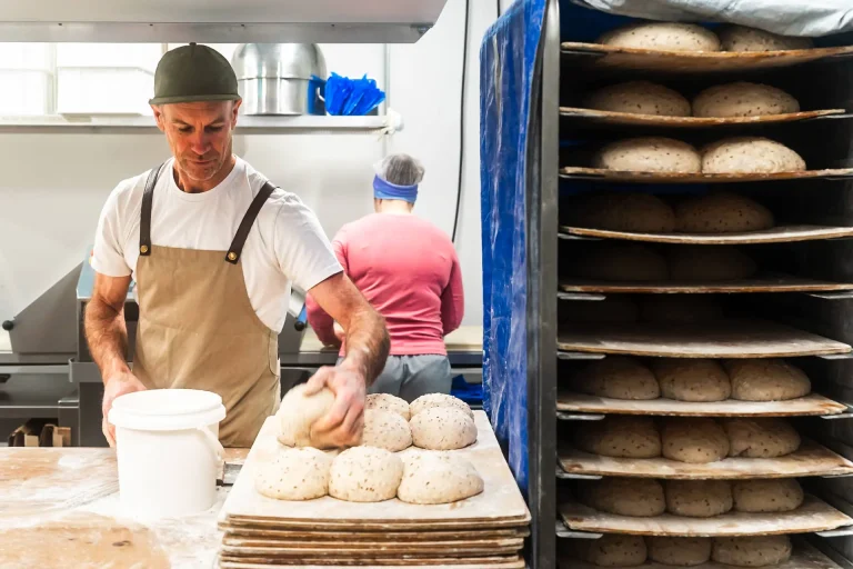 A baker shaping sourdough loaves