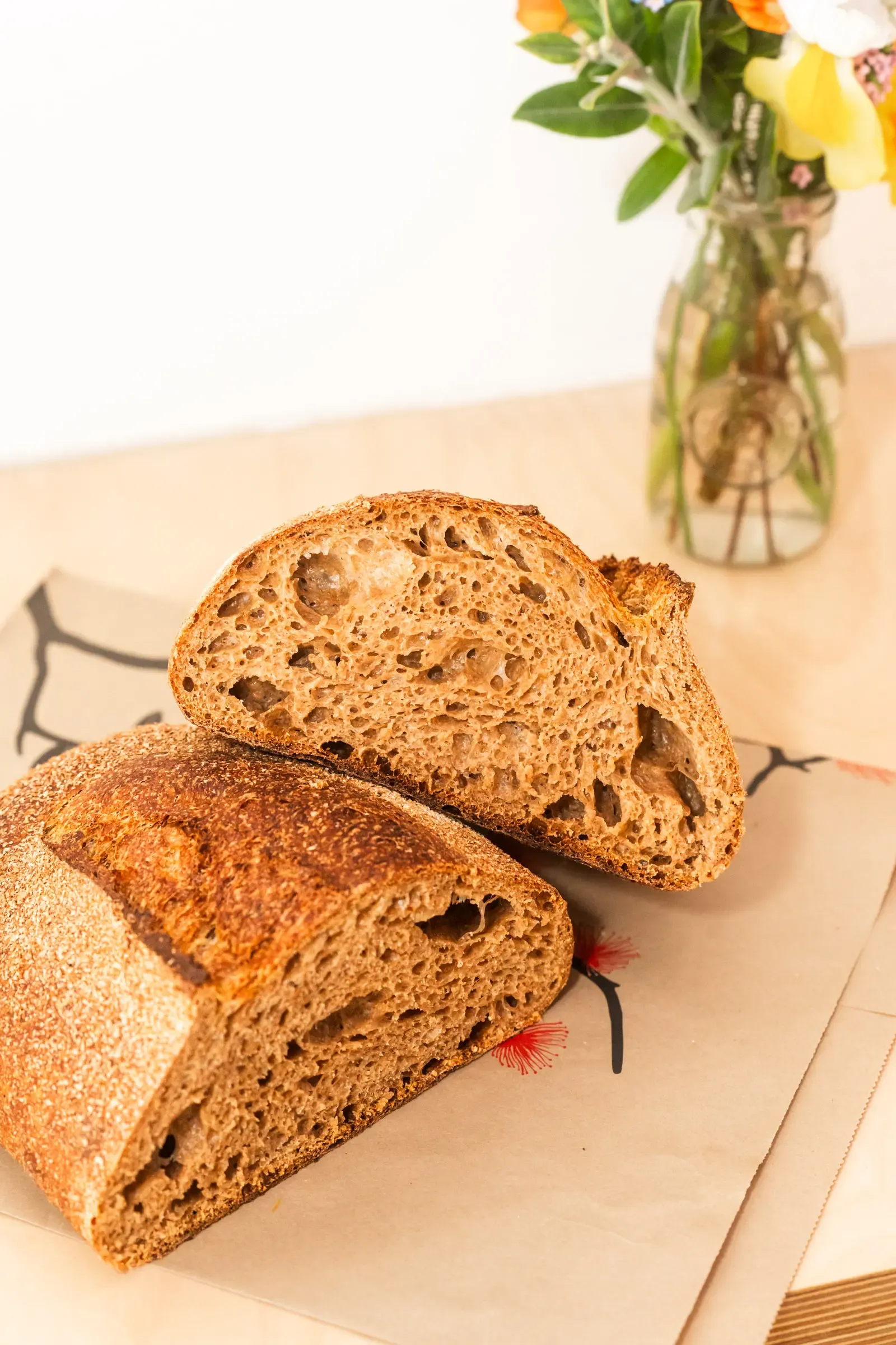 Organic Wholewheat Sourdough cut in half on board