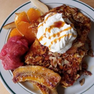 Close up of authentic French toast with cream, almonds and fruit