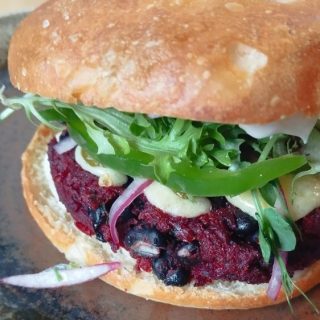 Beetroot Black Beans Burger with red onion, capsicum and cheese on a focaccia roll from Bellbird Bakery